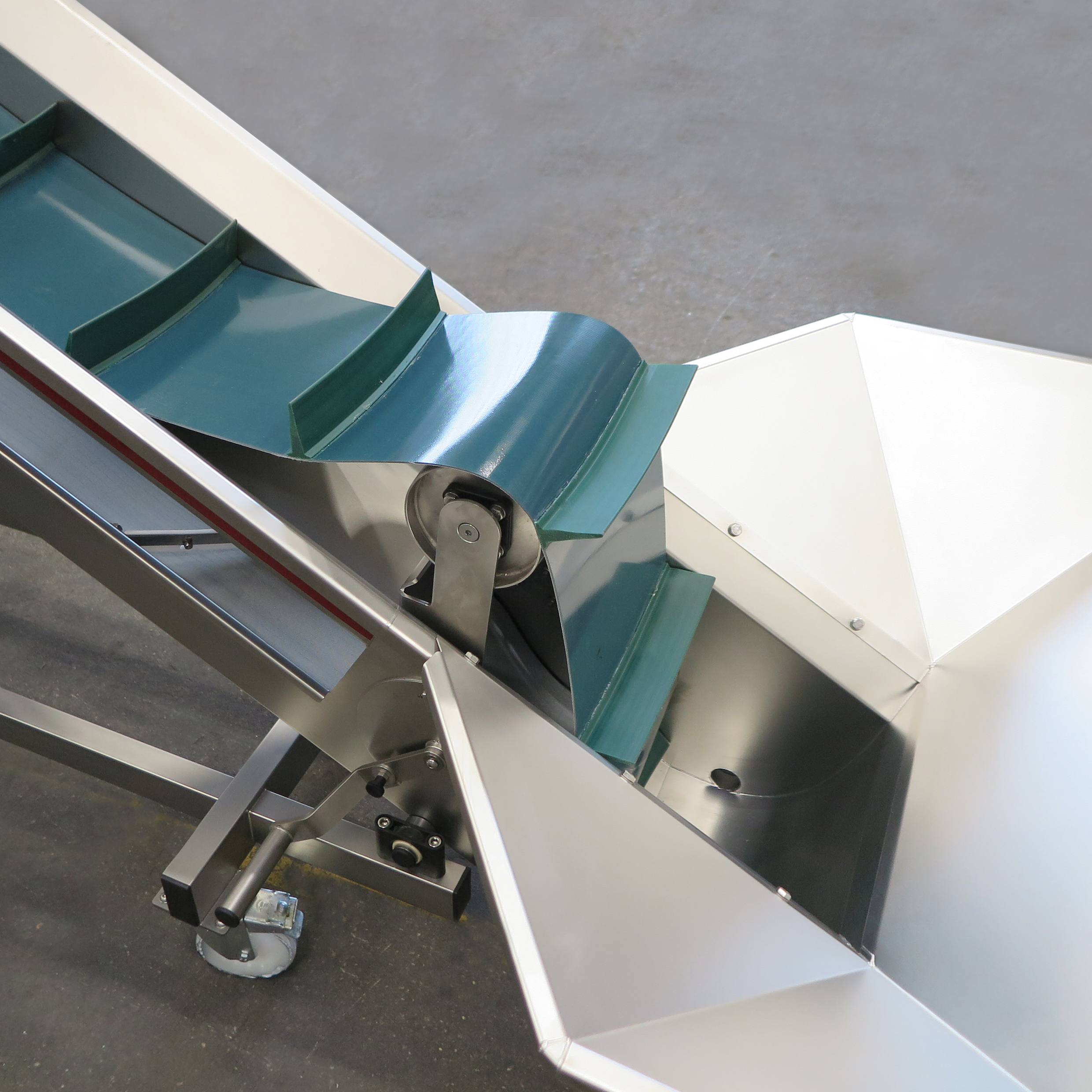 Nastro elevatore. Telaio autoportante in acciaio inox EN 1.4301 su ruote girevoli. Inclinazione regolabile del nastro. Nastro in PVC alimentare con listelli curvi. Sistema di tensionamento e rilascio (sblocco) rapido. Ugelli integrati per il risciacquo del nastro. Vaschetta recupero liquidi con scarico.